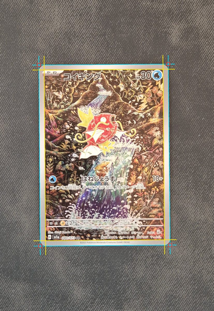 Photo of a Japanese Magikarp card on dark cloth with the detected corners, cut lines and print lines drawn over it